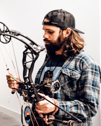 a man with a beard holding a bow and arrow